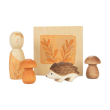 Freies Spiel: Hello autumn! – Eine Sammlung aus handbemalten Holzelementen: Peg-Puppe, zwei Pilzfiguren, ein geschnitzter Igel sowie ein herbstliches Holzbild, die zum Entdecken und Spielen einladen.