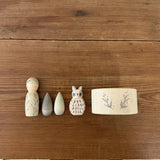 Freies Spiel: Hello winter! zeigt fünf handgefertigte Holzelemente auf einem Tisch: ein bemalter Peg-Doll, zwei tropfenförmige Blöcke, eine Eulenfigur und Washi-Tape, die winterliche Entdeckungen inspirieren.