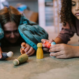 Kinder spielen auf dem Boden mit Freies Spiel: Animal Crew, einer Kollektion handgefertigter Holzfiguren von KLICKKLACK, die Ästhetik und Nachhaltigkeit in kindgerechtem Design vereinen.