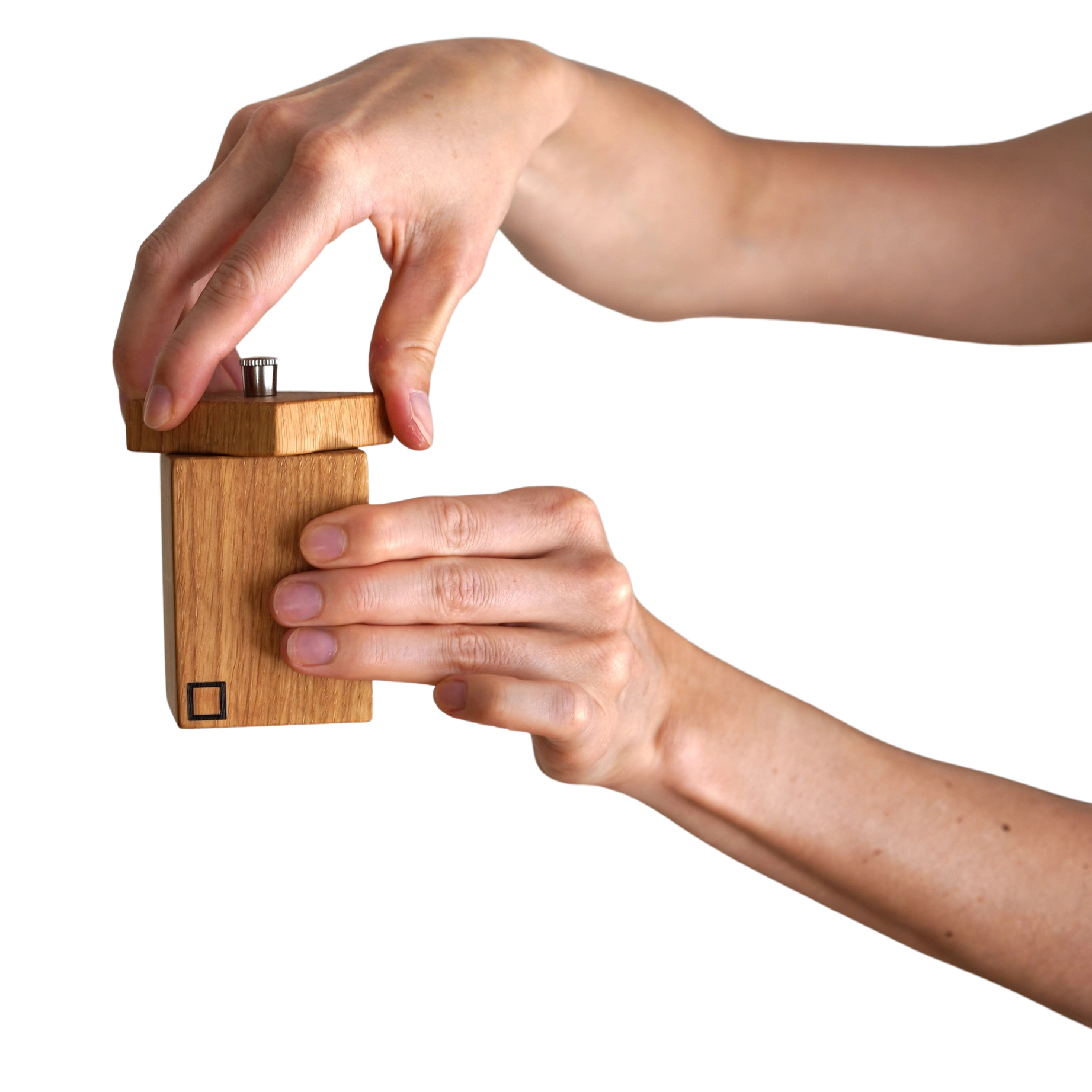 Eine Hand hält die Chilimühle, handgefertigt aus heimischem Eichenholz, veredelt mit Spezialbioöl. Perfekt für Designliebhaber und Genießer, hergestellt in einer kleinen Tischlerei im Bregenzerwald, Österreich.
