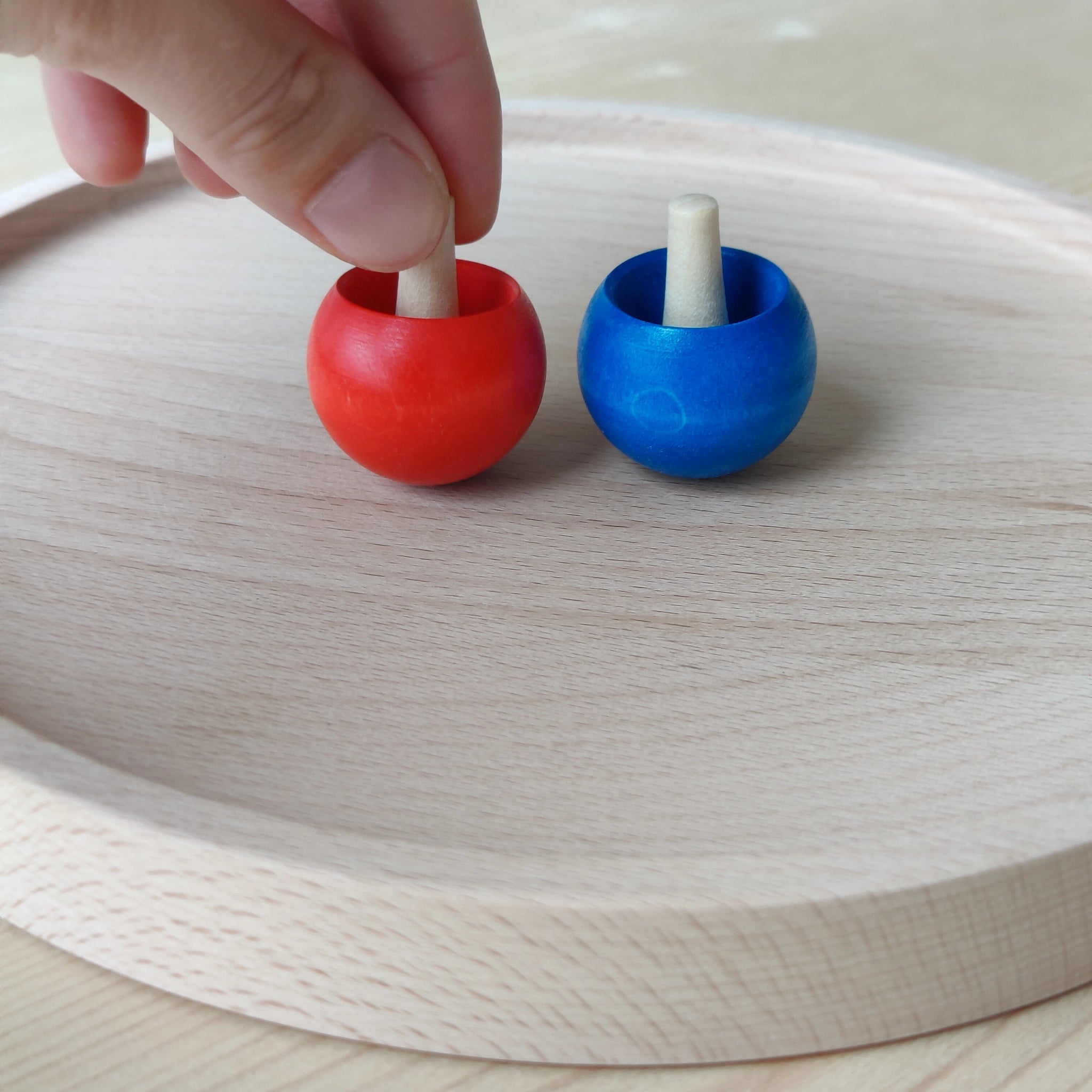 Nahaufnahme des Kreiseltellers aus massivem Buchenholz mit erhöhtem Rand, der das Wegrollen der Holzkreisel verhindert. Ideal zum Spielen, hergestellt in einem deutschen Familienbetrieb, repräsentiert KLICKKLACKs ästhetische und nachhaltige Philosophie.