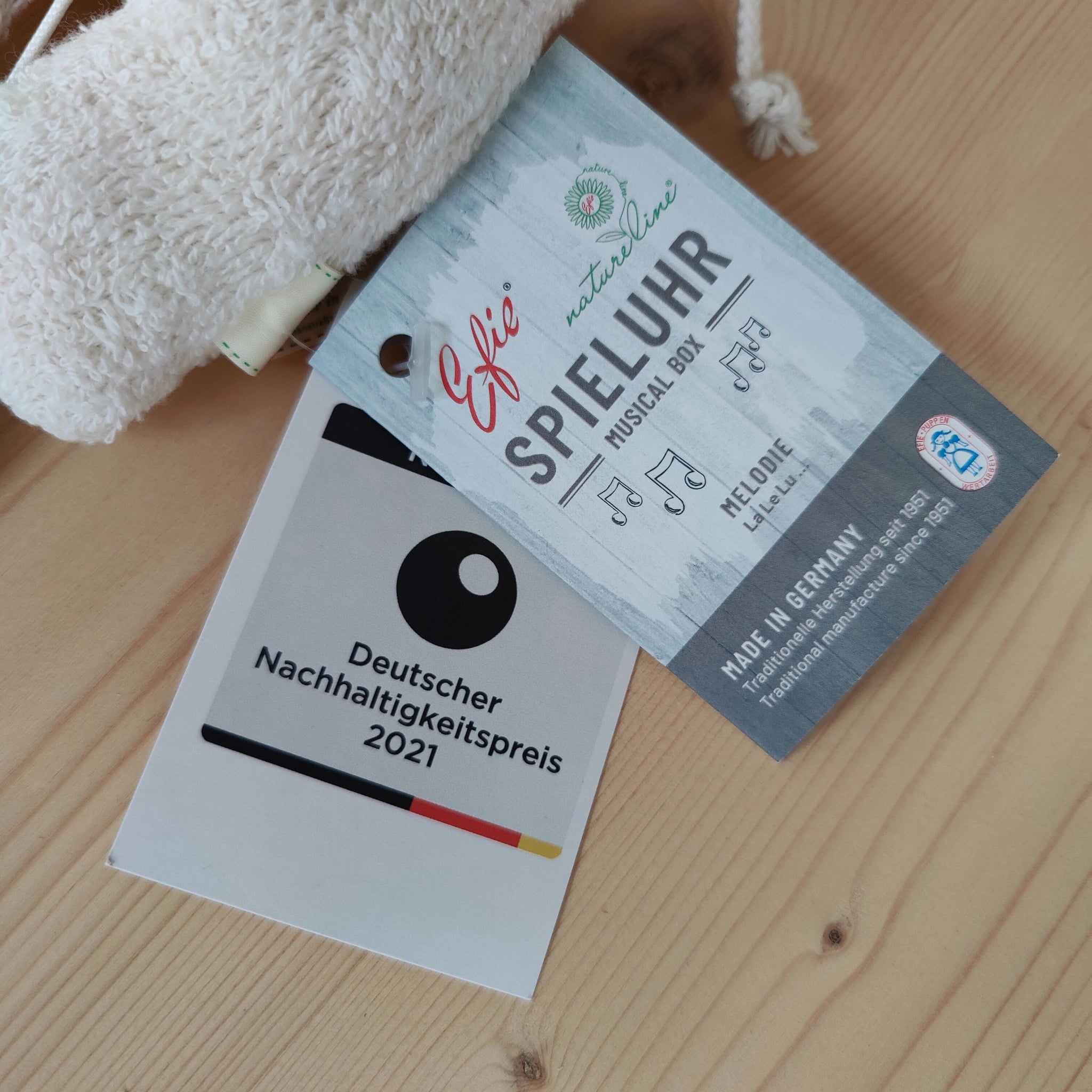Spieluhr: Elefant aus weicher Bio-Baumwolle und Schafwolle, zeigt ein kunstvolles Blütendesign. Perfekt für ein natürliches Einschlafritual, spielt sanft LaLeLu. Hergestellt in deutscher Manufaktur.