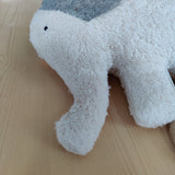 Spieluhr: Elefant, ein weiches Stofftier aus Bio-Baumwolle und Schafwolle, auf einem Tisch. Es ist ein hochwertiges, in Deutschland gefertigtes Produkt, ideal für ein sanftes Einschlafritual.