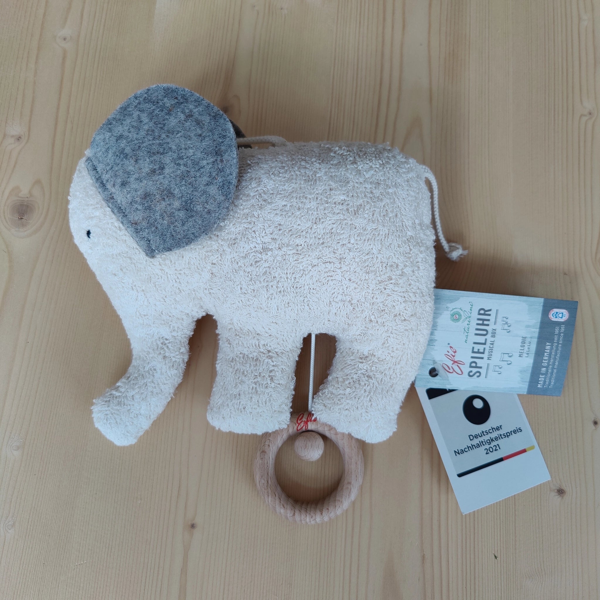 Spieluhr: Elefant, aus weicher Bio-Baumwolle und Schafwolle, mit wasserbeständigem Spielwerk auf Holzring montiert. Handgefertigt in Deutschland, spielt sanftes LaLeLu-Gutenachtlied, ideal für ein natürliches Einschlafritual.
