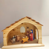 Krippe aus massivem Fichtenholz mit handgeschnitzten Figuren von Josef, Maria und dem Jesuskind in einem schlichten Stall mit Schindeldach und Fenster, gefertigt in einer deutschen Holzmanufaktur.