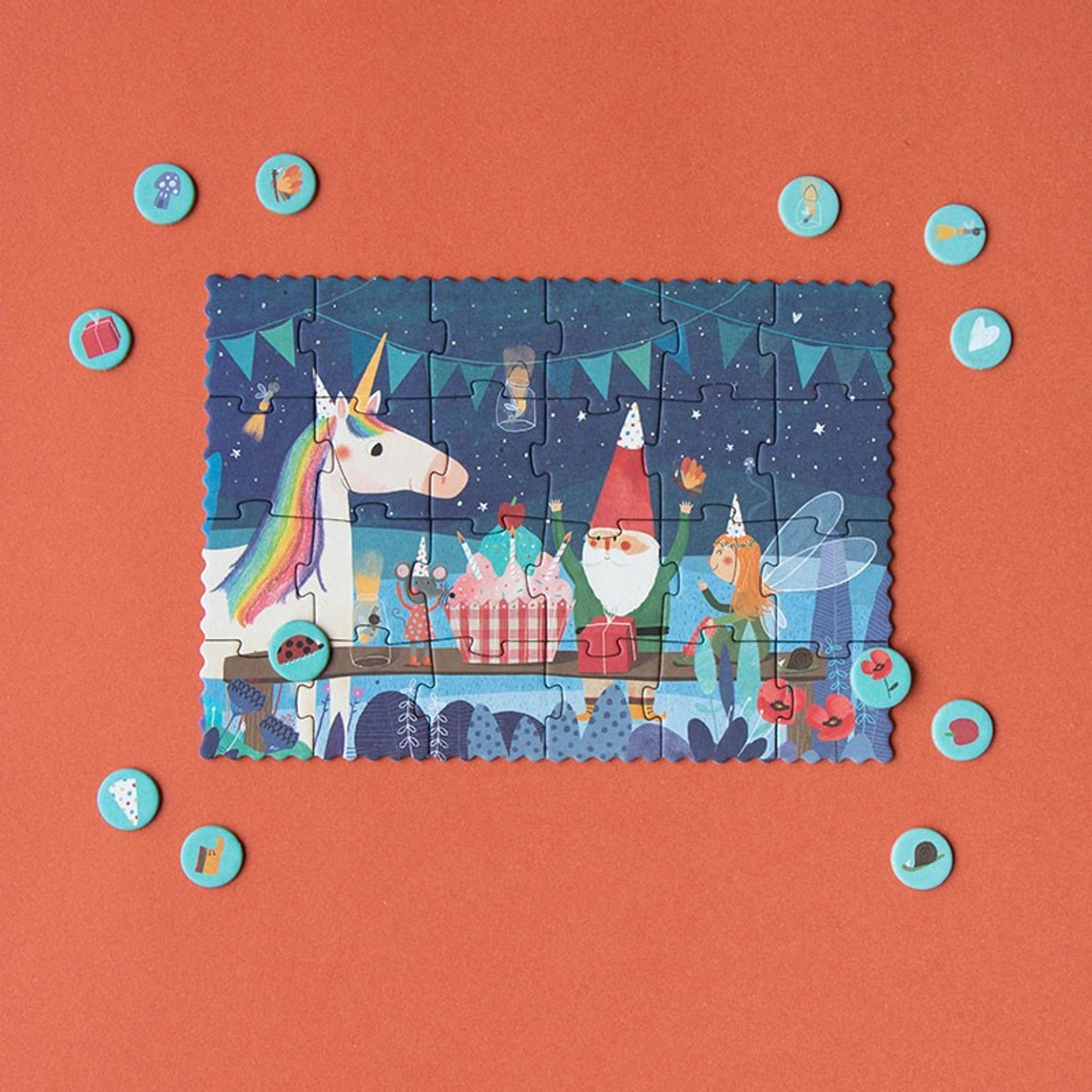 Minipuzzle: Unicorn zeigt eine verspielte Nachtparty mit Einhorn, Gnom, Fee und Mäusen. Umgeben von türkisfarbenen Markern, fördert es Beobachtung und Entdeckung. Nachhaltig in Spanien aus recycelten Materialien hergestellt.