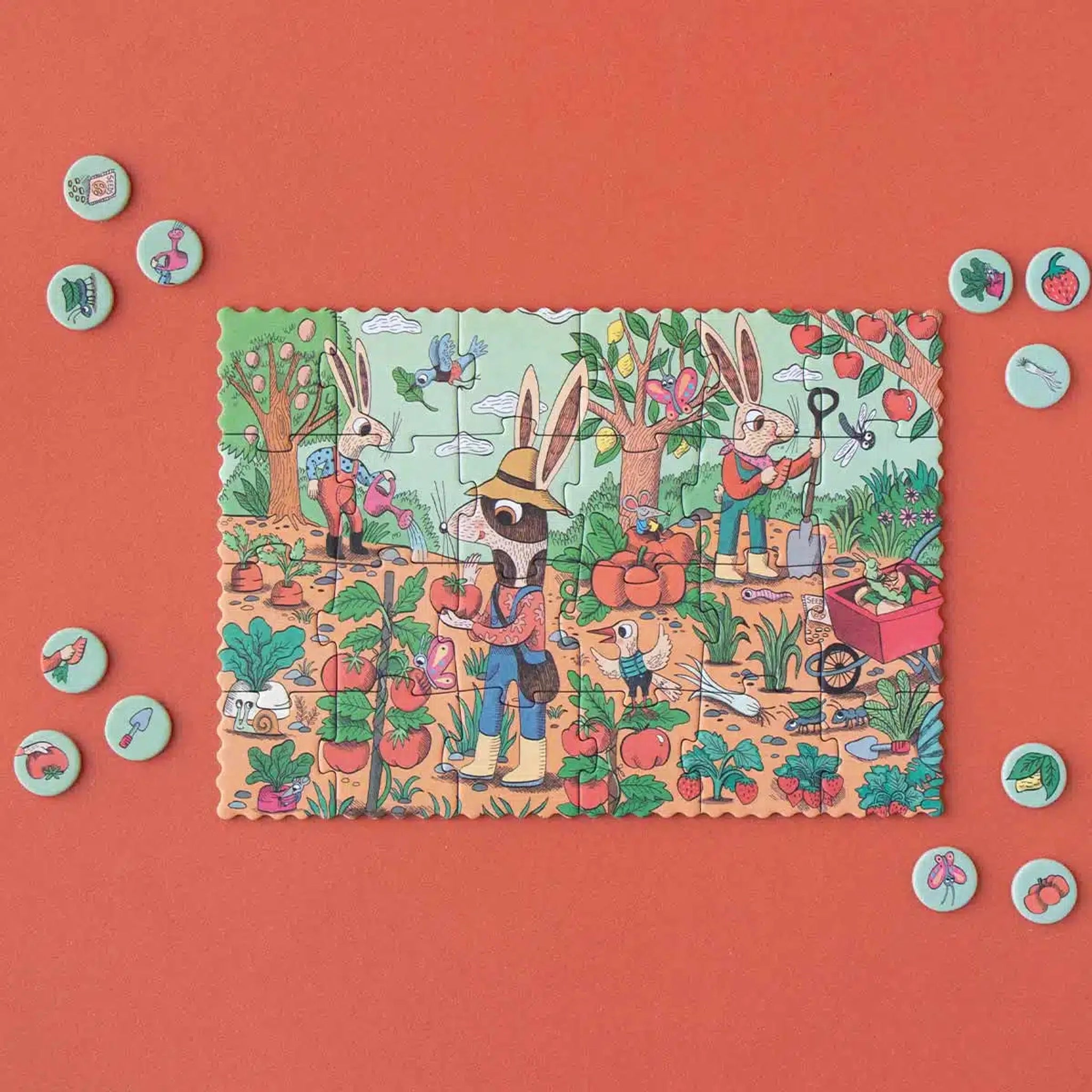 Minipuzzle: Garden zeigt drei anthropomorphe Hasen im Garten mit frischem Gemüse. Rund um das Puzzle liegen runde Spielsteine mit Gartensymbolen. Nachhaltig aus FSC-Papier und recyceltem Karton, ideal für Kinder ab 4 Jahren.