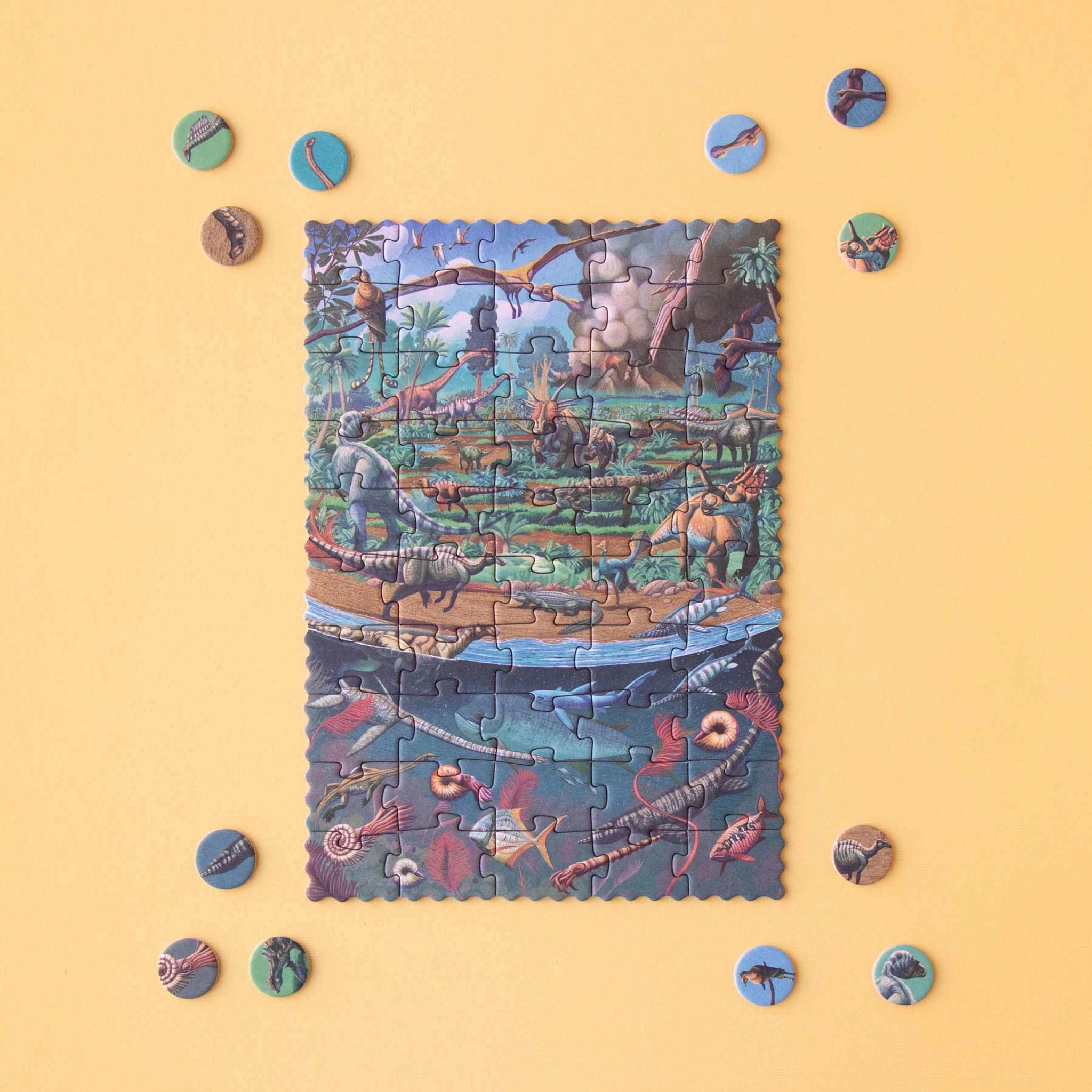 Minipuzzle: Dinosaurs zeigt ein fast fertiggestelltes Puzzle mit prähistorischer Welt, inklusive Dinosauriern und Meeresleben, auf einem Tisch. Umgeben von runden Puzzleteilen, ideal für Kinder ab 5 Jahren.