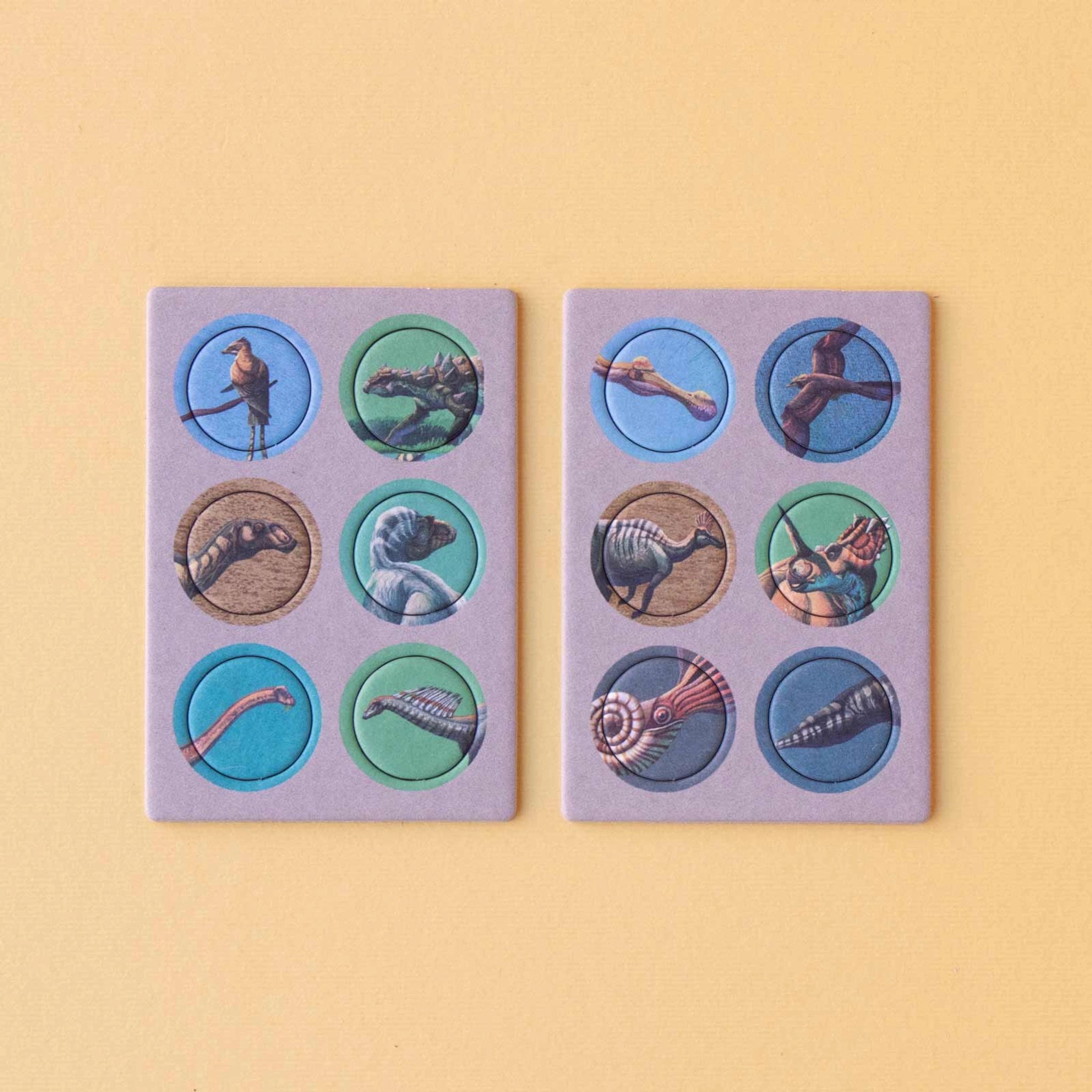 Minipuzzle: Dinosaurs zeigt zwei Pappspieltafeln mit drehbaren Scheiben, die prähistorische Kreaturen kombinieren. Ideal für Kinder ab 5 Jahren, aus nachhaltigen Materialien, perfekt für unterwegs und liebevoll in Spanien gefertigt.