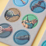 Minipuzzle: Dinosaurs – Nahaufnahme eines Kartonbogens mit herausbrechbaren Scheiben, bedruckt mit prähistorischen Kreaturen, ideal für Kinder ab 5 Jahren. Nachhaltig aus FSC-Papier und recyceltem Karton gefertigt.