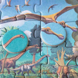 Minipuzzle: Dinosaurs, ein 50-teiliges Dinosaurier-Puzzle mit Sauropoden und Pterosauriern, zwei runde Kartonmarken zeigen Dinosaurierköpfe, aus FSC-Papier und recyceltem Karton, ideal für Kinder ab 5 Jahren.