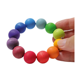 Perlenring regenbogenfarbig: Ein handgehaltener Greifling aus großen, lebhaft bemalten Holzperlen auf elastischem Band. Ideal für Babys, um erstes Greifen zu fördern. Handgefertigt in einer deutschen Manufaktur.