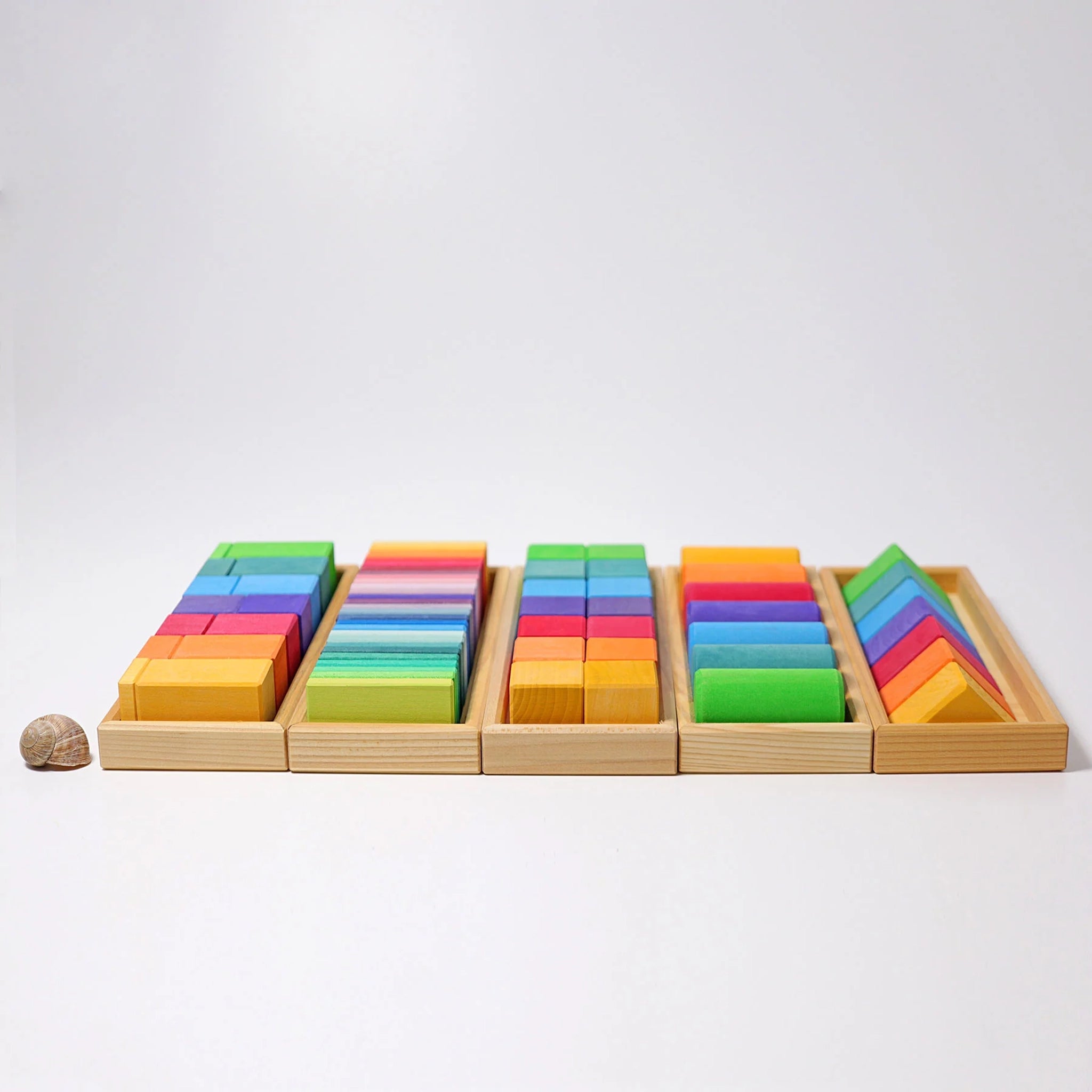 Bausteine: Formen und Farben – Ein Set aus 70 regenbogenfarbenen Montessori-Holzblöcken in fünf stapelbaren Trays. Perfekt zum spielerischen Lernen von Farben und Formen, hergestellt nachhaltig in Deutschland.