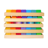 Bausteine: Formen und Farben zeigt einen Holzrahmen mit 70 farblich lasierten Lindenholzklötzen, ideal für Montessori-Lernen. Perfekt zum Erforschen von Farben und Formen, handgefertigt in Deutschland.