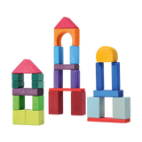 Bausteine: Bunte Geoklötze (30-teilig) zeigen fantasievolle Strukturen aus bunten Holzblöcken, darunter ein zweistöckiges Haus, ein hoher Turm und ein einfaches Bauwerk, ideal für kreative, nachhaltige Bauprojekte.