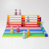 Freies Spiel: Kleine Stufenpyramide aus farbig lasiertem Lindenholz zeigt eine moderne, minimalistische Konstruktion aus pastellfarbenen Bauklötzen mit Figuren, die die Kreativität und Feinmotorik fördern.