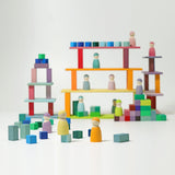 Freies Spiel: Kleine Stufenpyramide aus farblich lasiertem Lindenholz, zeigt pastellfarbene Holzfiguren und Bauklötze in minimalistischem Design, ideal zur Förderung von Kreativität und Feinmotorik, hergestellt in Deutschland.