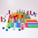 Freies Spiel: Kleine Stufenpyramide – Ein Arrangement aus bunten, rechteckigen Holzplättchen, Holzfiguren und Würfeln für kreatives Spielen. Hergestellt aus lasiertem Lindenholz, fördert es Feinmotorik und Kreativität.