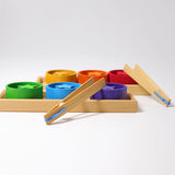 Freies Spiel: Sortierspiel Regenbogenschälchen – ein Montessori-Spiel aus geöltem Holz, bestehend aus sechs runden Holzscheiben mit Sternen und zwei Holzpinzetten, fördert Feinmotorik und Konzentration.