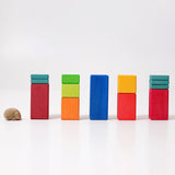 Freies Spiel: Große Stufenzählstäbe, fünf Türme aus bunten Holzklötzen in einer Reihe, links ein Schneckenhaus; fördert räumliches Denken und Mathematik, nachhaltig in Deutschland hergestellt.