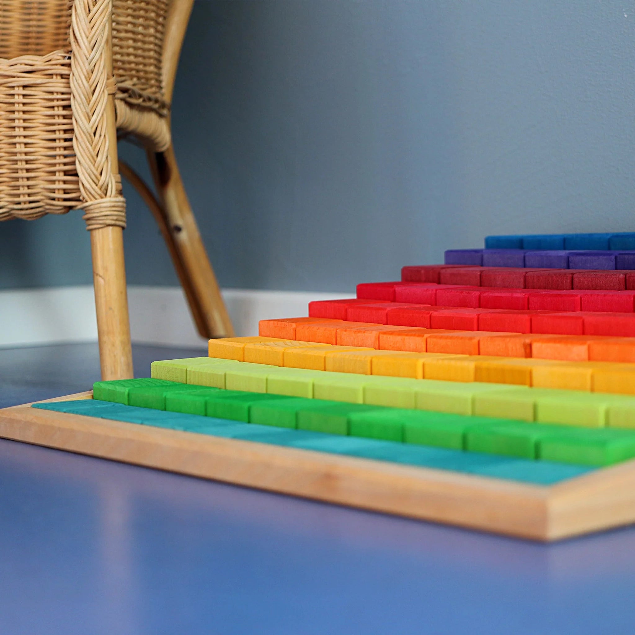 Freies Spiel: Große Stufenzählstäbe, ein Set aus 100 lasierten Lindenholz-Bauklötzen, präsentiert in einem Holzrahmen. Fördert räumliches Denken und Mathematikverständnis, ideal für nachhaltige, ästhetische Lernumgebungen.