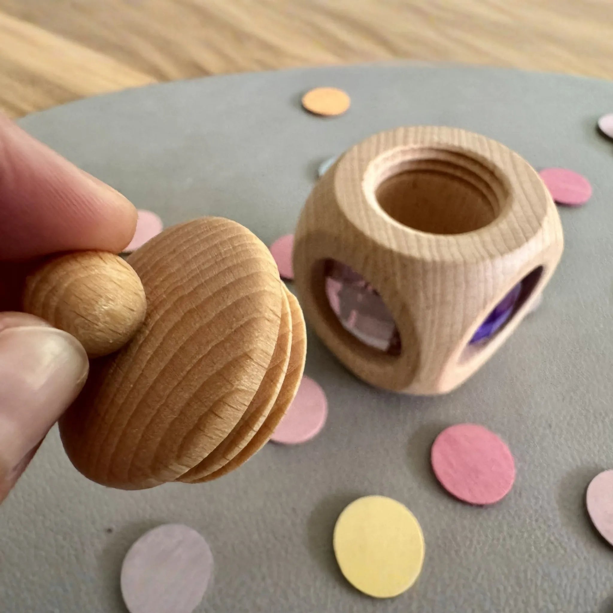 Pastellfarbene Zahndose aus Holz in einer dekorierten Spielsituation.