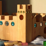 Kleines Märchenschloss zwischen weiteren Bauspiel-Holzteilen.