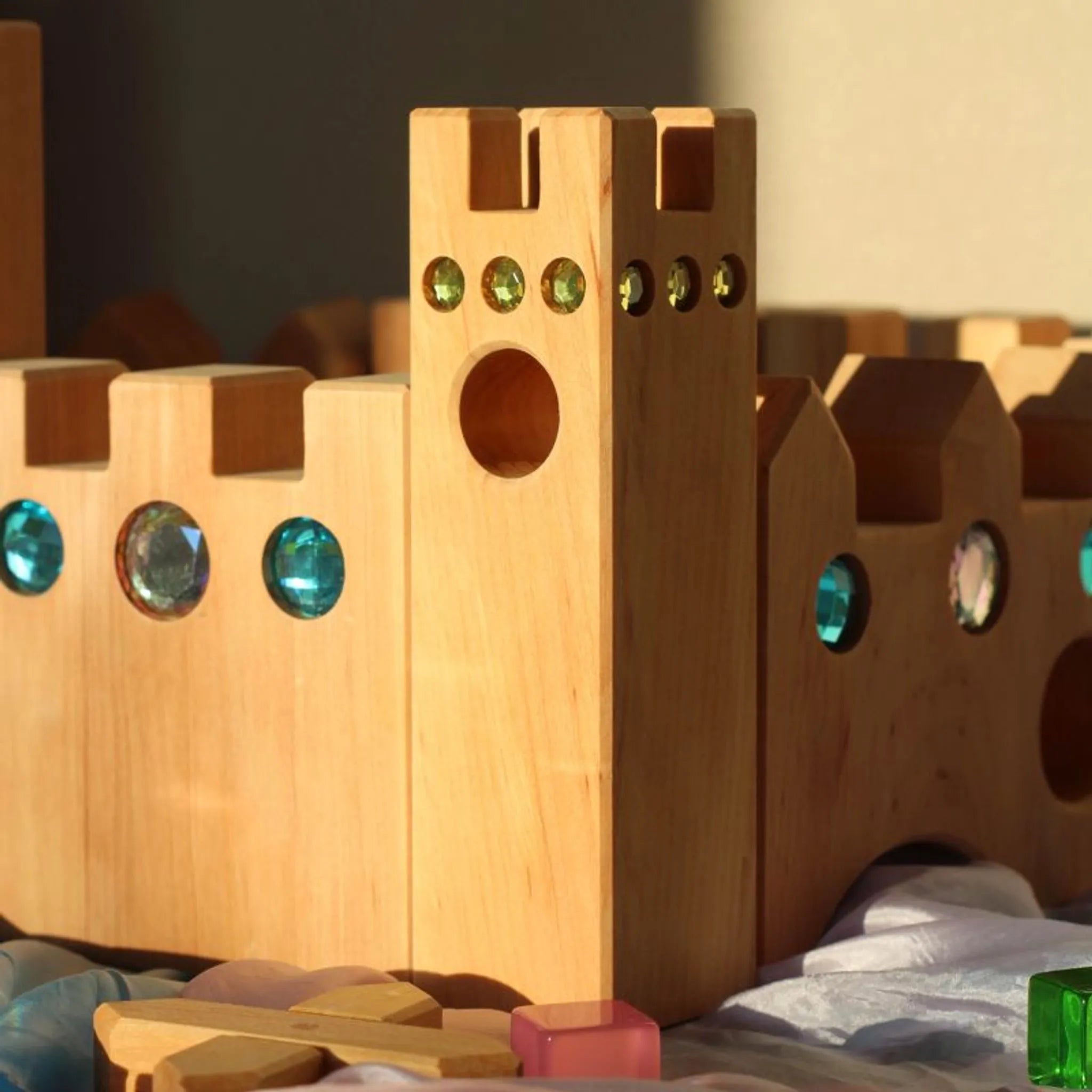 Kleines Märchenschloss zwischen weiteren Bauspiel-Holzteilen.