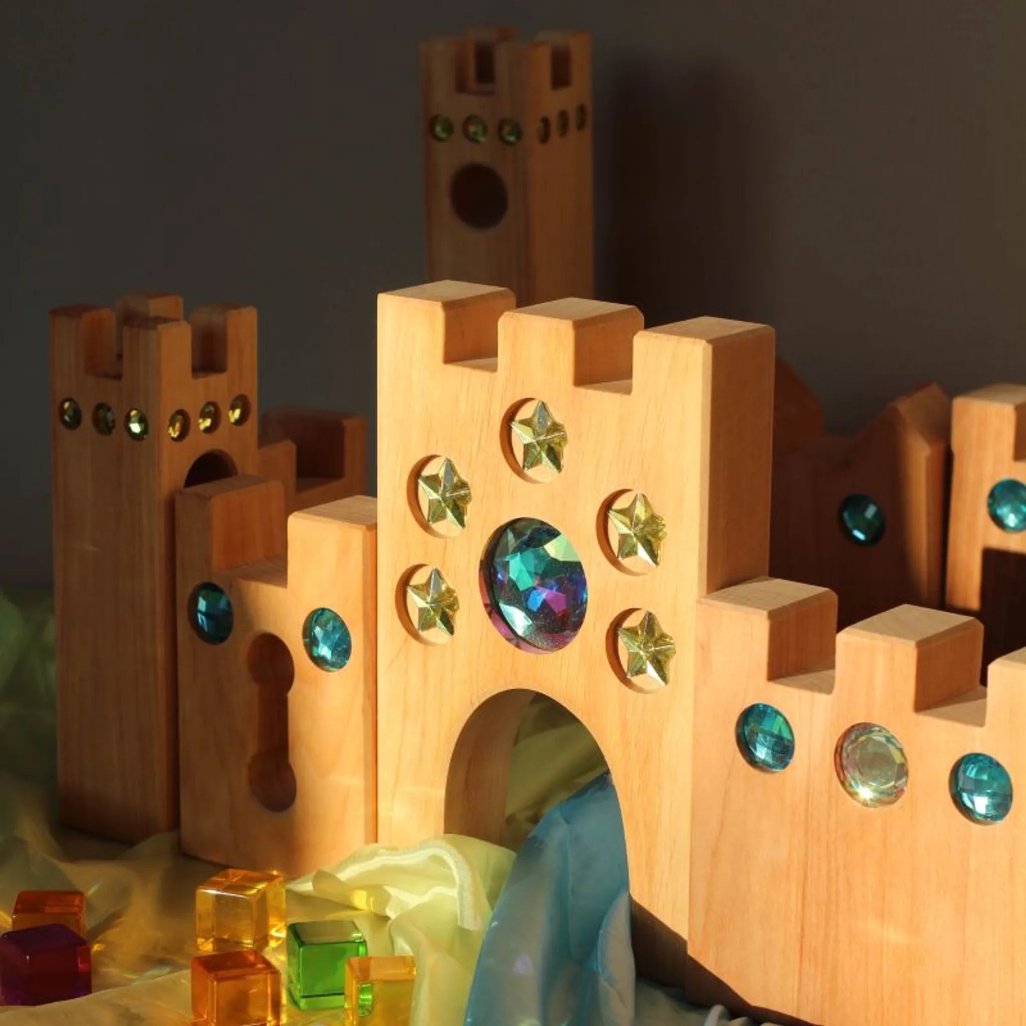 Märchenschloss aus Holz mit Türmen und farbigen Bauelementen.
