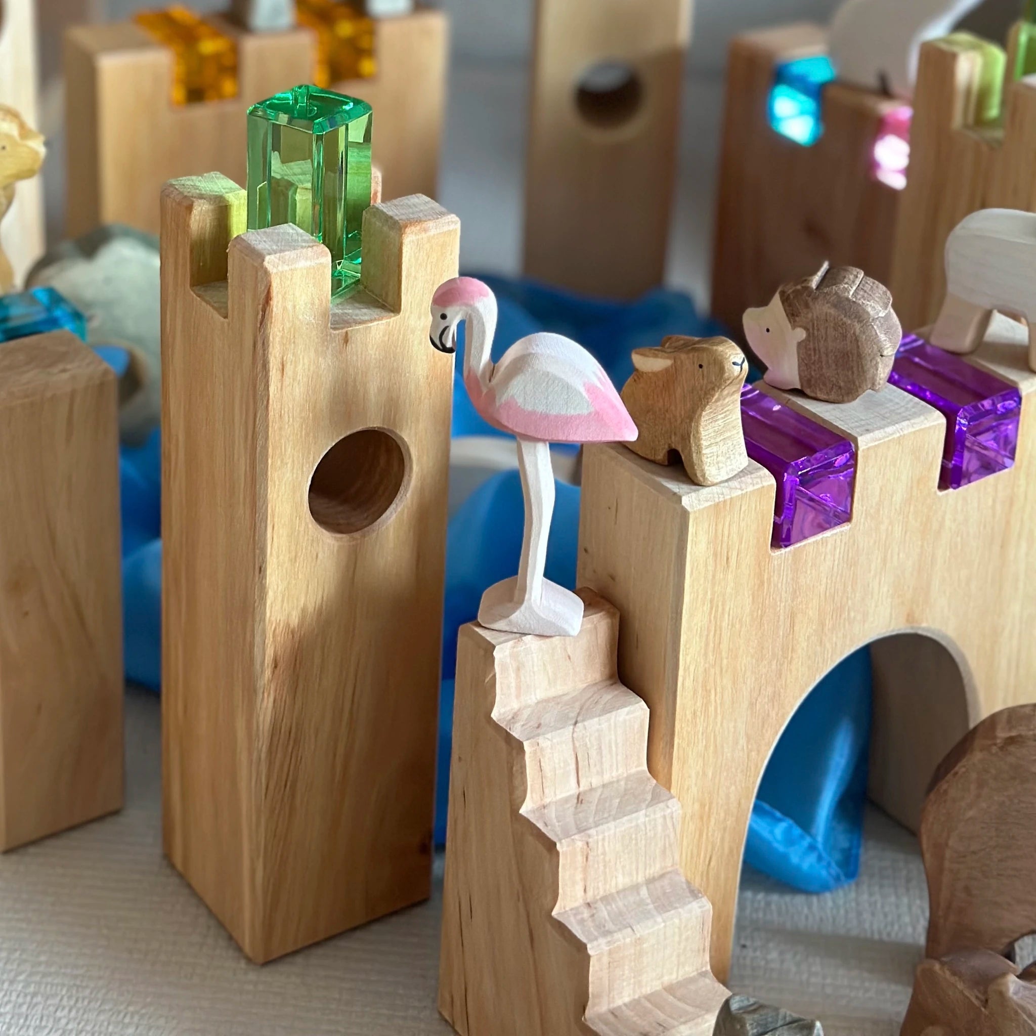Kind spielt mit einer Ritterburg aus Holzbausteinen.
