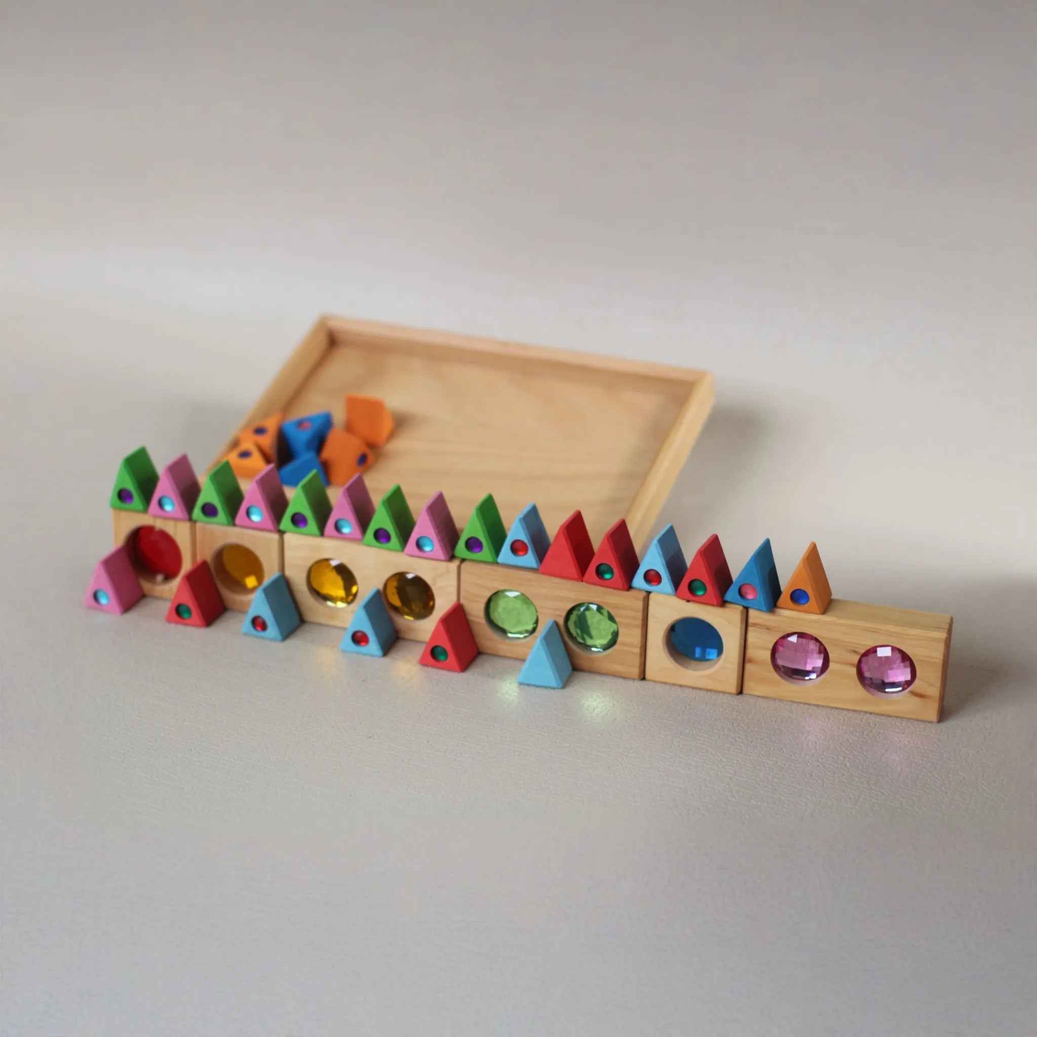 Kind sortiert kleine Holzteile in einer Bauspiel-Sammlerbox.