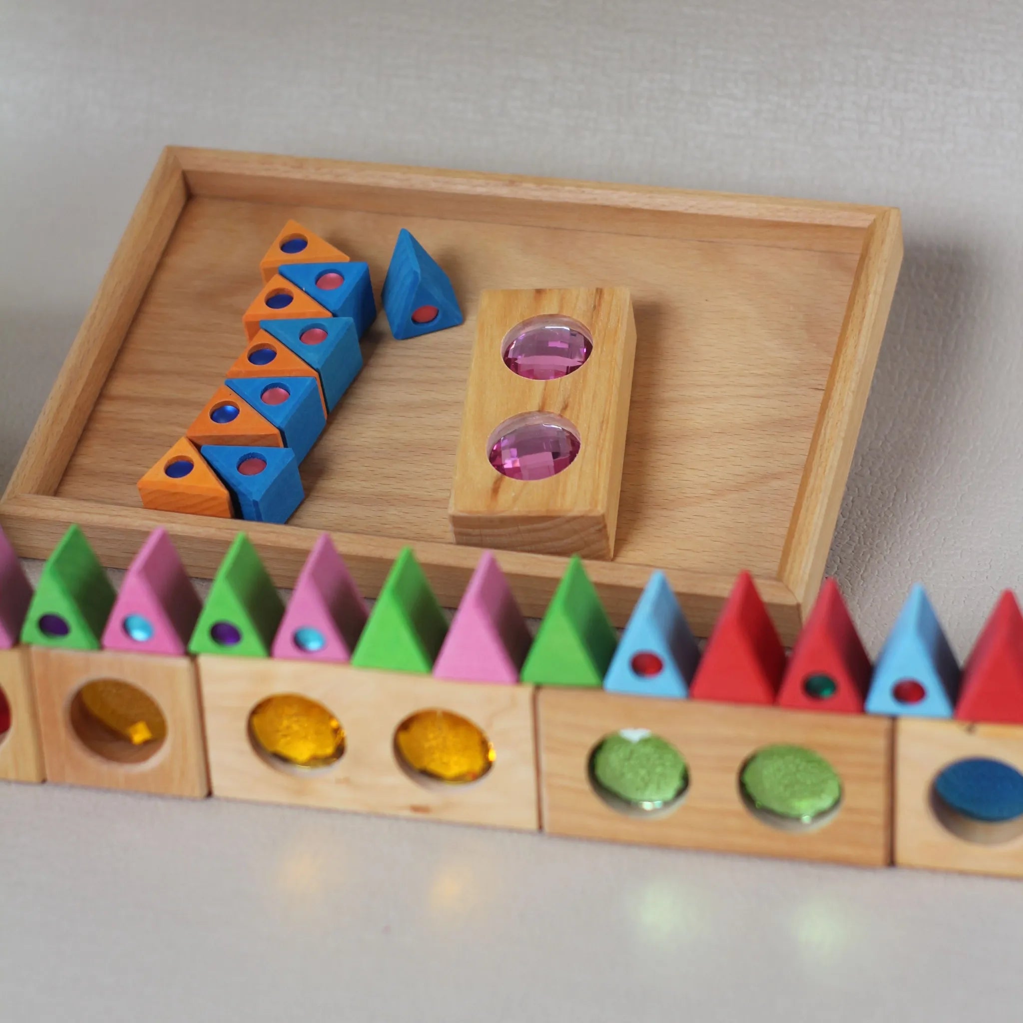 Holz-Sammlerbox mit kleinen Formen und Bauelementen.