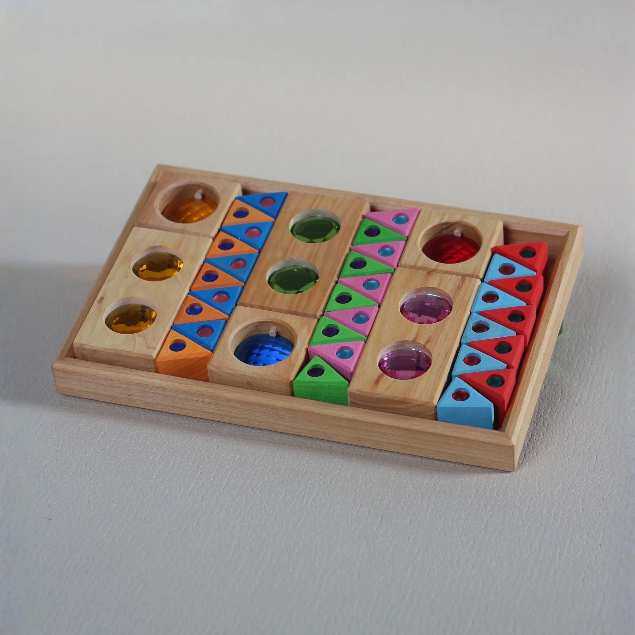 Geöffnete Holzbox mit sortierten Bauspiel-Elementen.