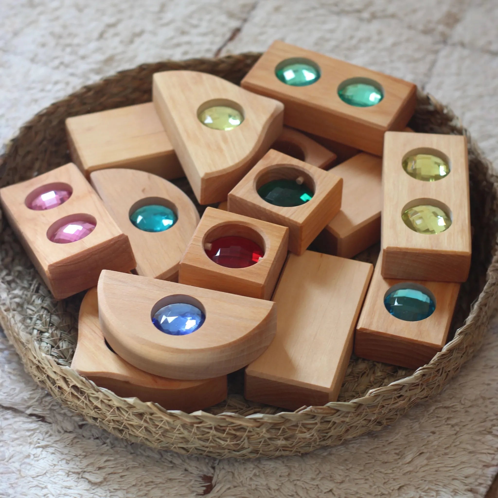 Kleine farbige Holzteile aus der Mini-Mixed-Box auf einer Fläche.