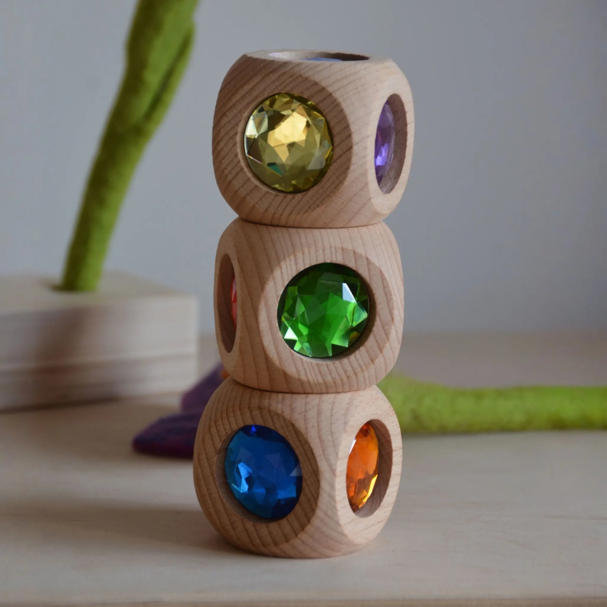 Kind spielt mit mehreren Zauberwürfeln aus Holz.