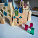 Bauspiel-Holzteile und transparente Elemente in einer Spielsituation.