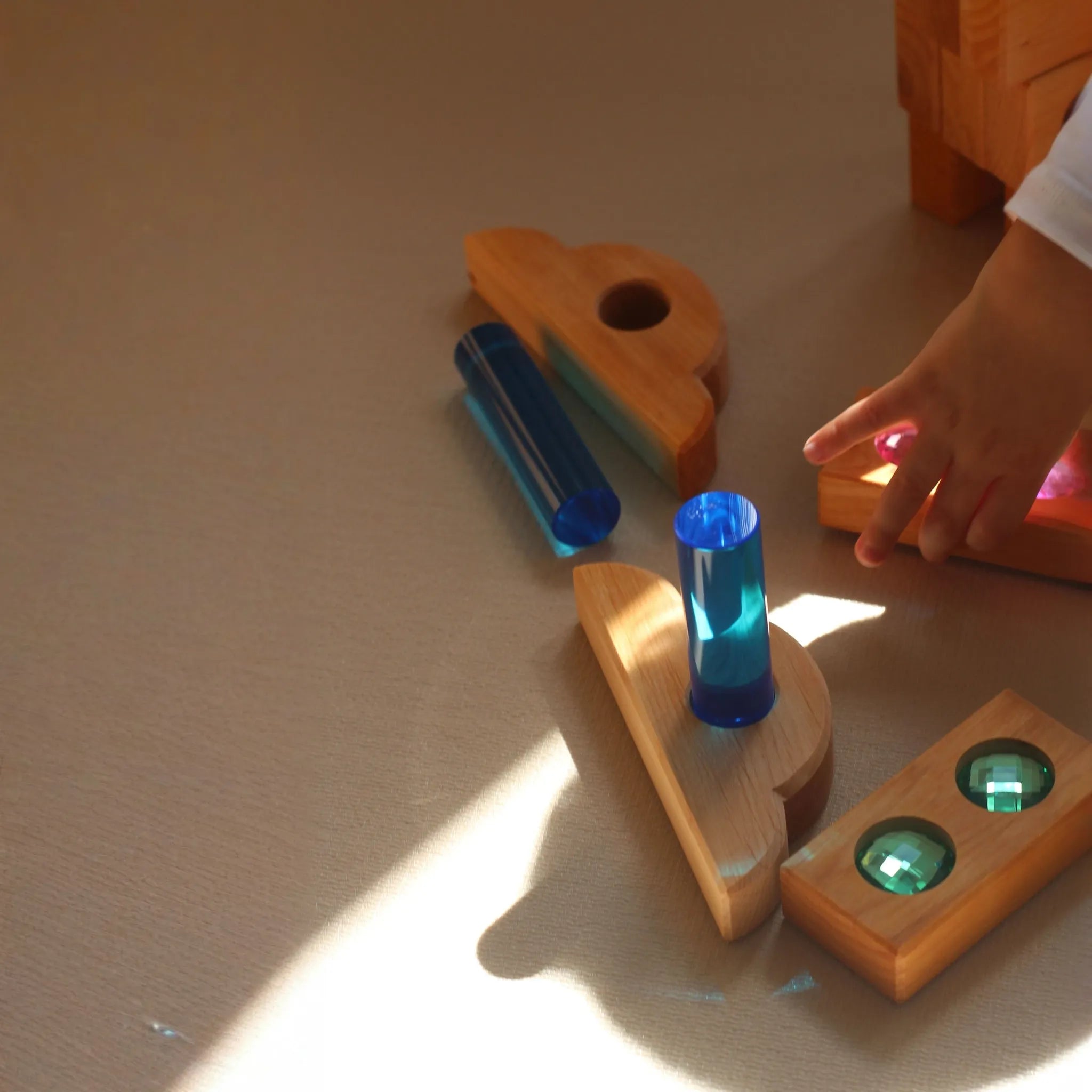 Kleine Bauspiel-Holzteile zwischen weiteren Bauelementen.