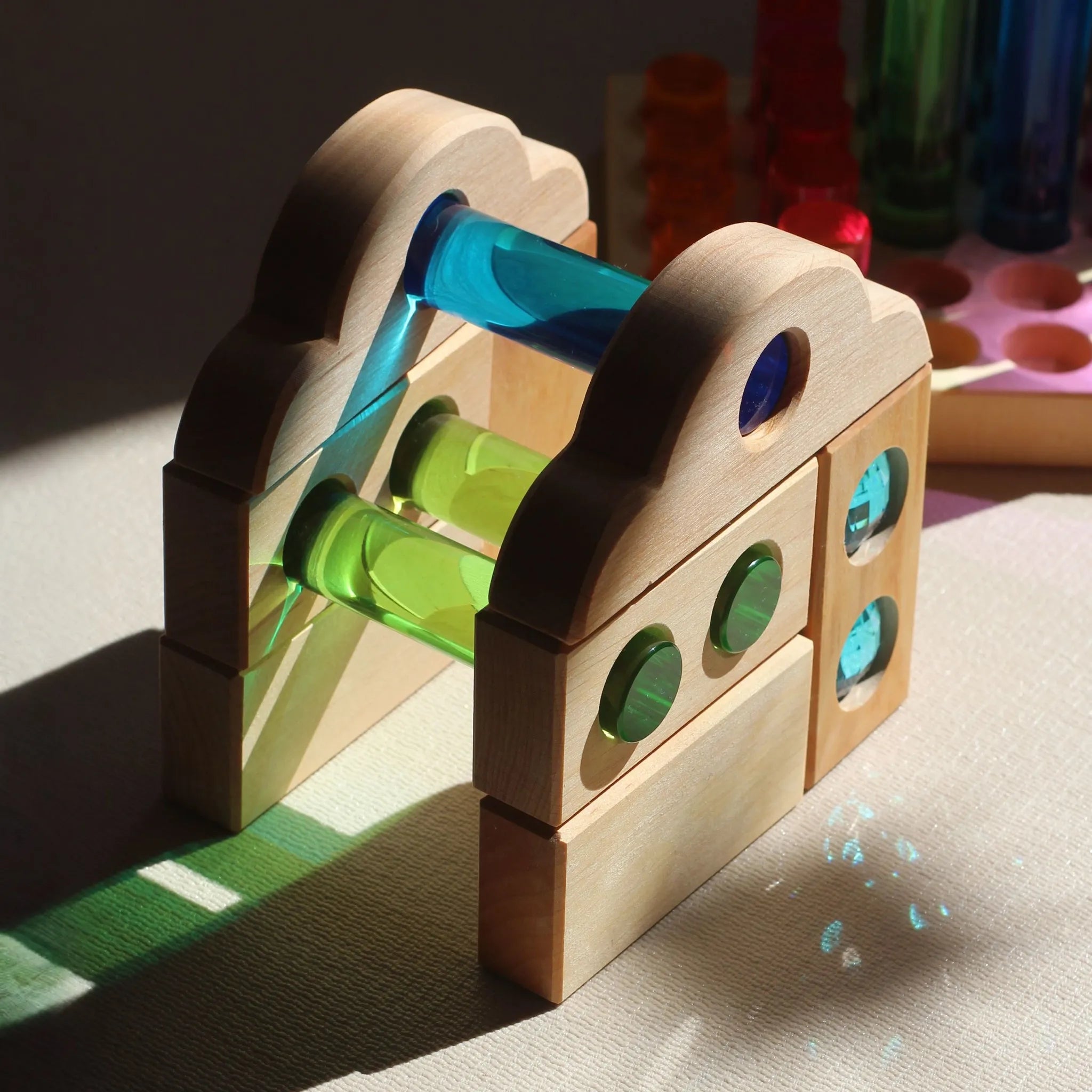 Verschiedene kleine Bauspiel-Holzformen in einer Spielszene.
