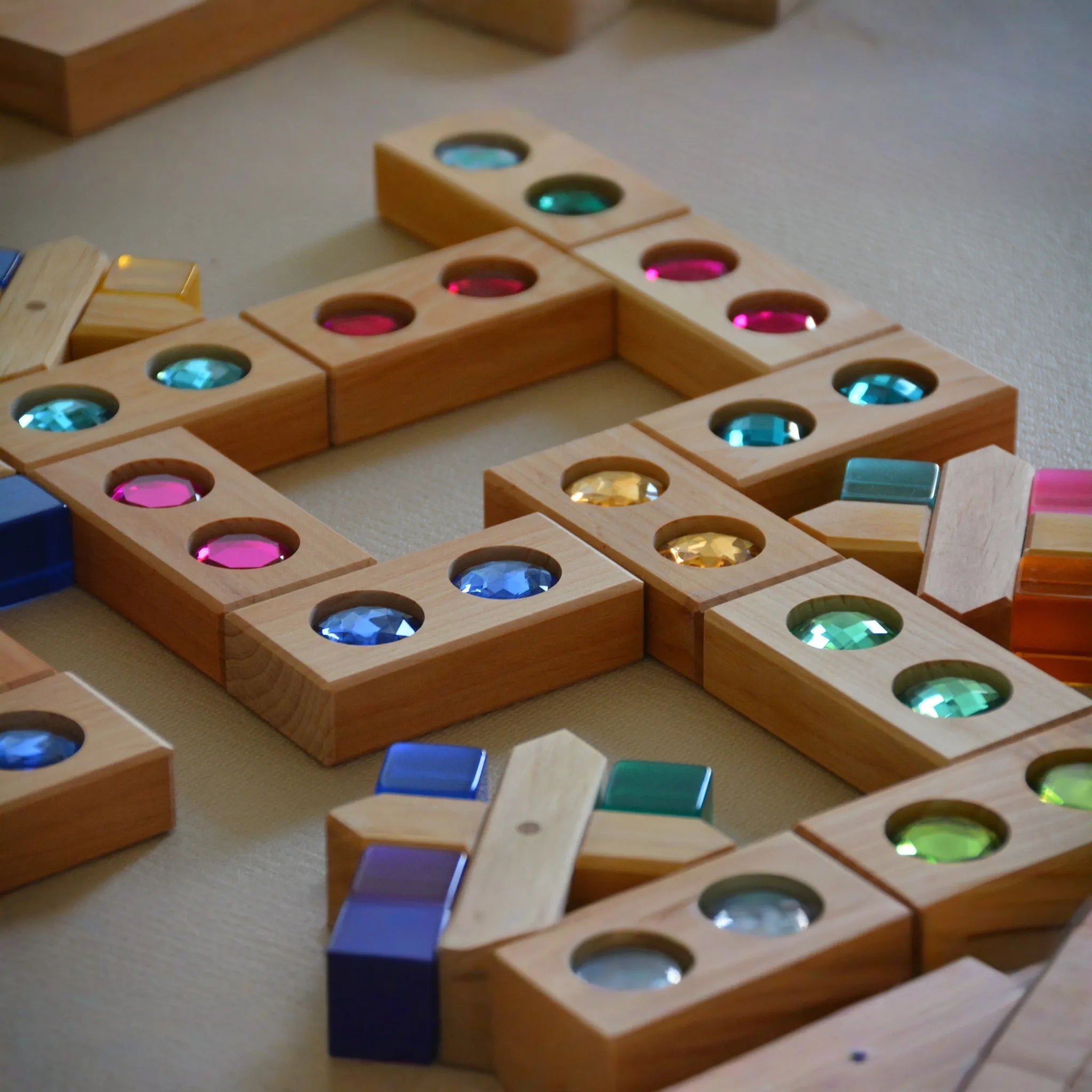 Bauspiel-Holzteile einschließlich X-Klötzen in einer Spielszene.