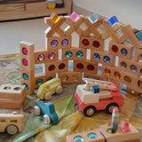Bauspiel-Bauelemente mit farbigen Öffnungen in einer Spielsituation.