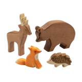 Vier handgefertigte Holzfiguren aus dem Set: Waldtiere von KLICKKLACK, bestehend aus einem Hirsch, Bär, sitzendem Fuchs und kleinem Igel, ideal für nachhaltige und ästhetische Dekoration.
